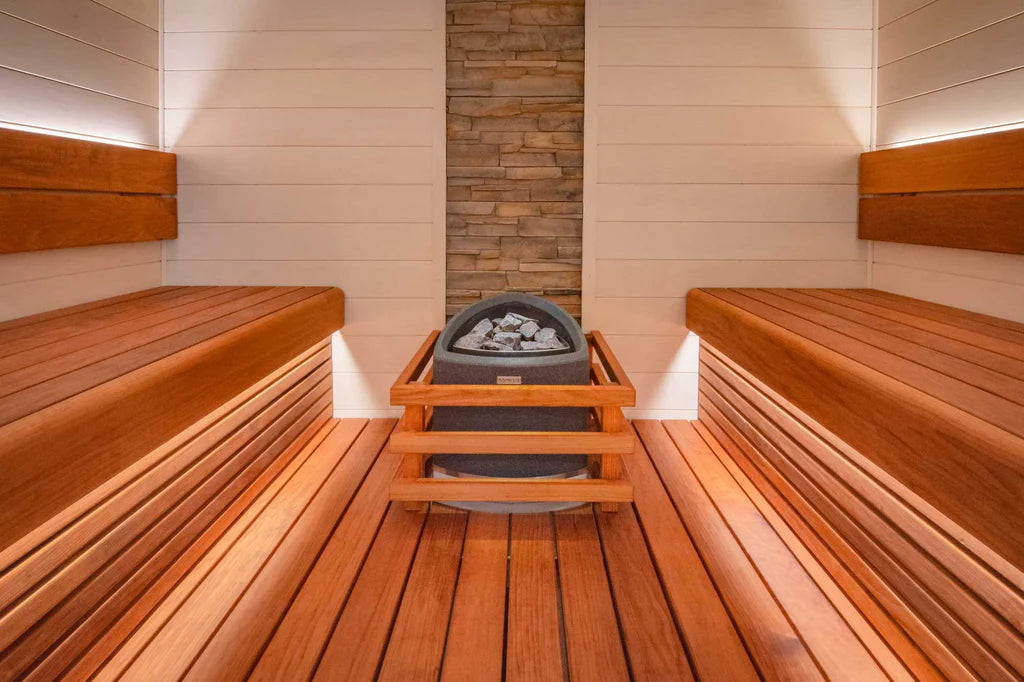 Custom Sauna With Stone Feature and White Cladding and Orange Benches Facing Each Other