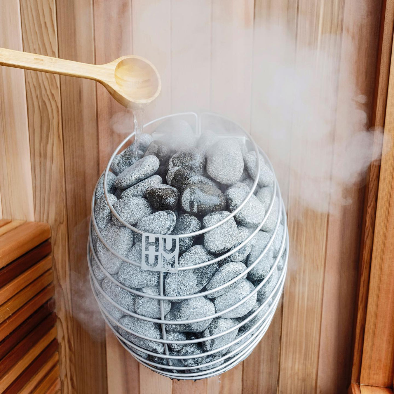 HUUM Drop Sauna Heater with Water Being Poured on It Creating Steam