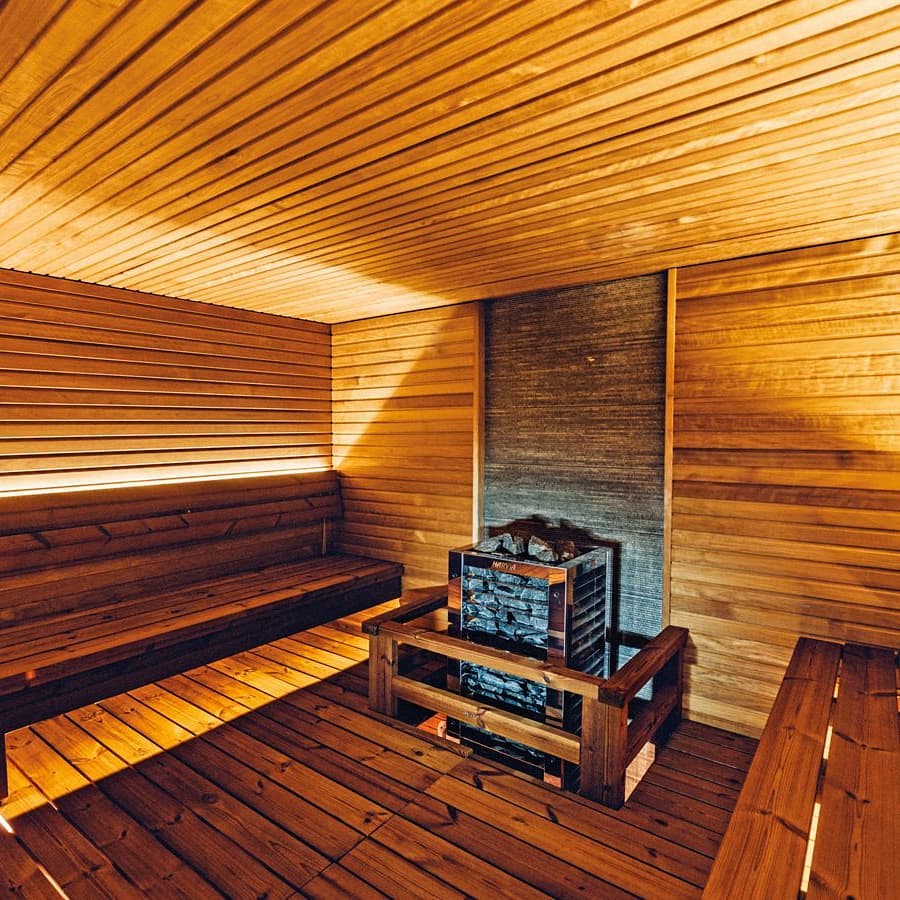 Rustic Custom Sauna With 2 Benches Facing Each Other and Heater in The Center